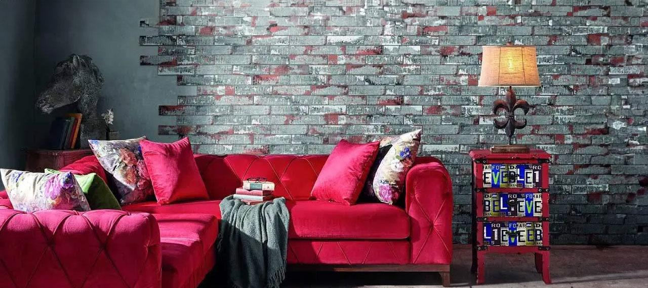 Intérieur avec canapé rouge et mur carrelé avec des briques bicolores de style industriel