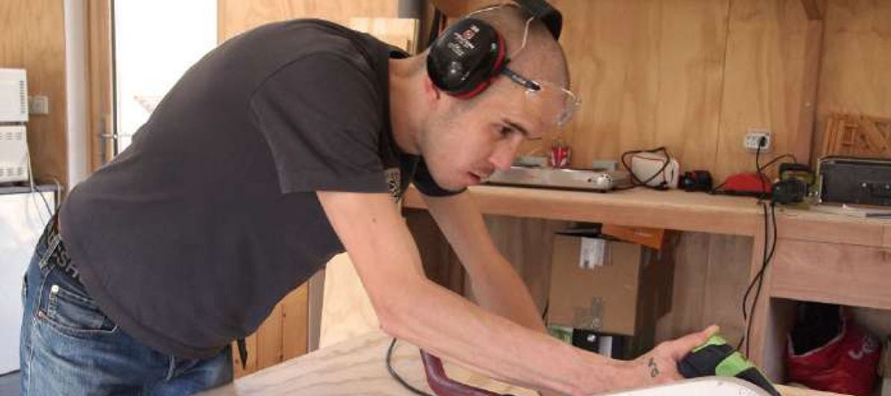 Jeune homme coupant du bois
