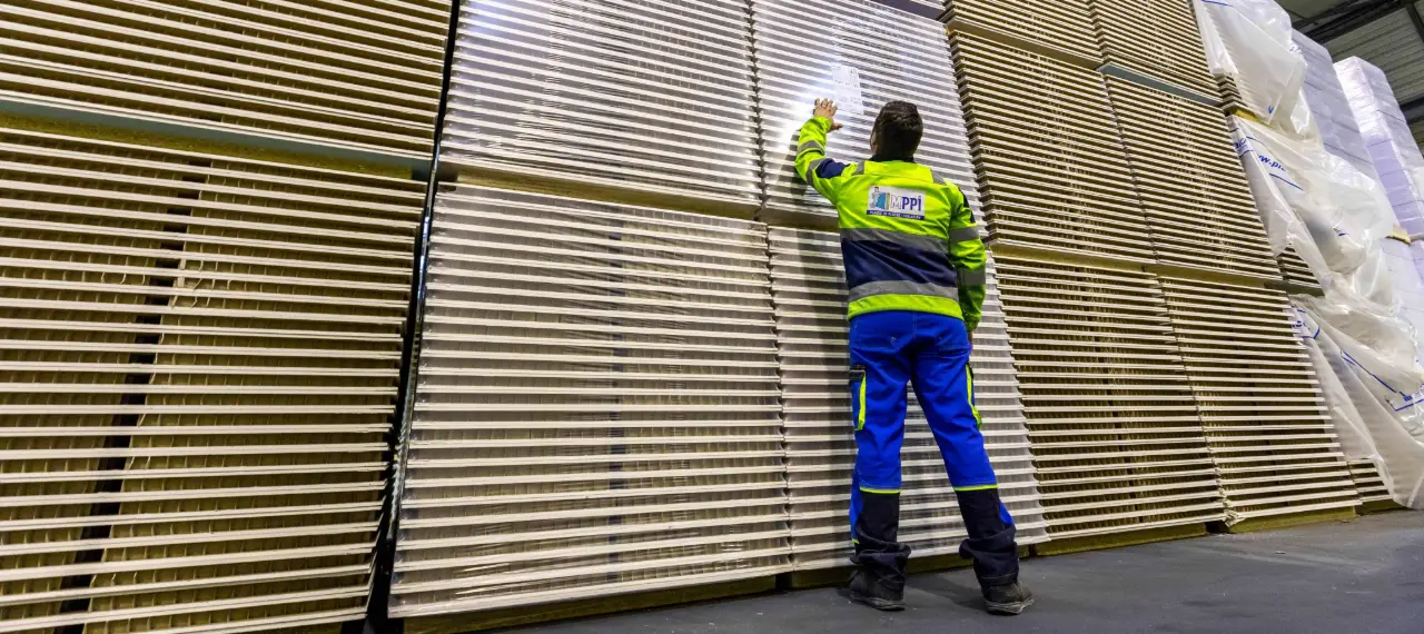 un homme devant des piles de plaques de plâtre