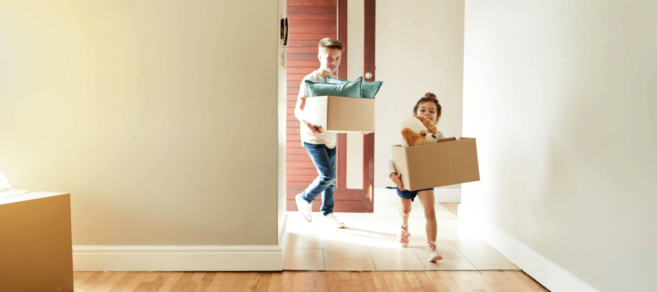 2 enfants entrent dans un nouvel appartement avec leurs cartons