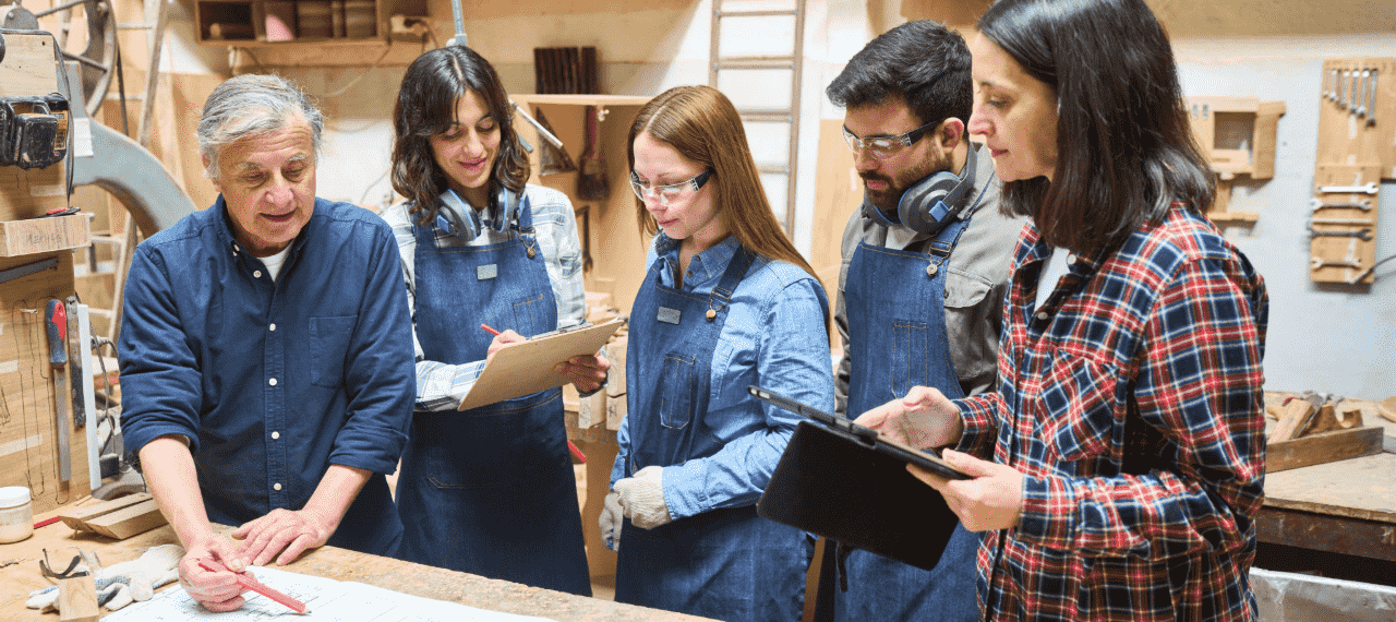 groupe de jeunes dans un atelier menuiserie avec un professeur