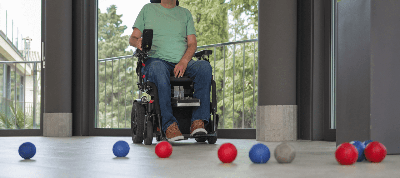 personne en fauteuil qui joue à la boccia