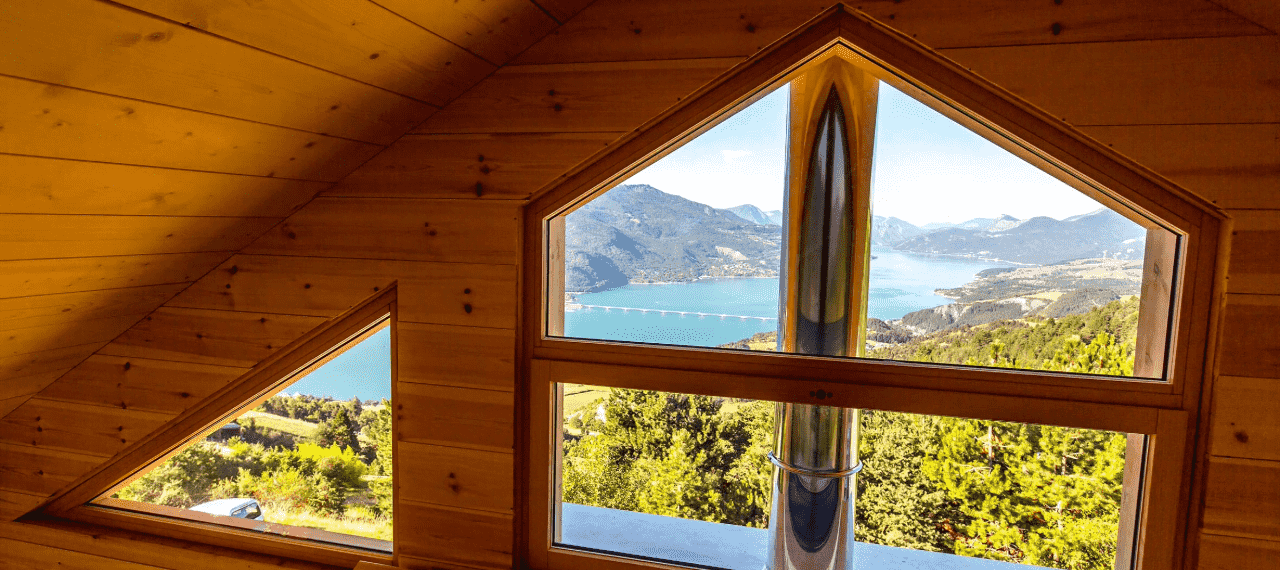 fenêtre intérieure en bois dan sun chalet avec vue extérieure sur un lac