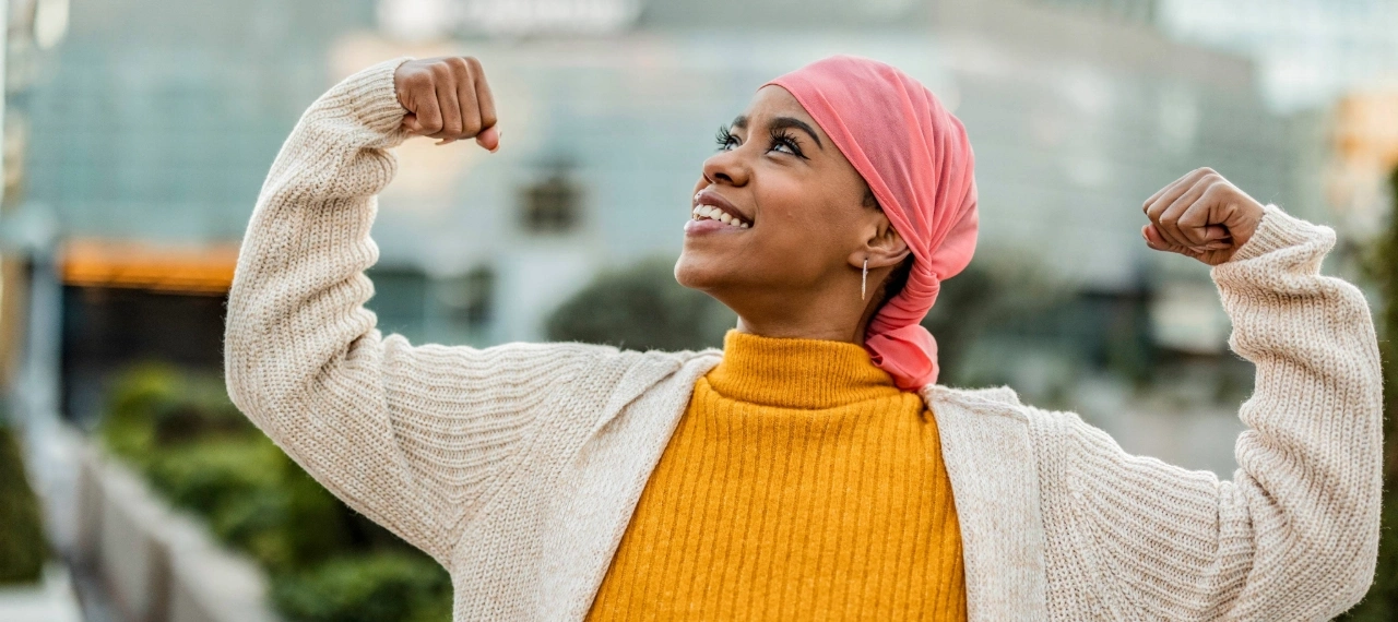 femme avec un foulard sur la tête les bras en l'air