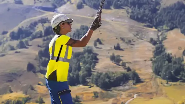 Extrait de la couverture du rapport RSE 2024 : une femme en train d'ajuster le câble d’une grue
