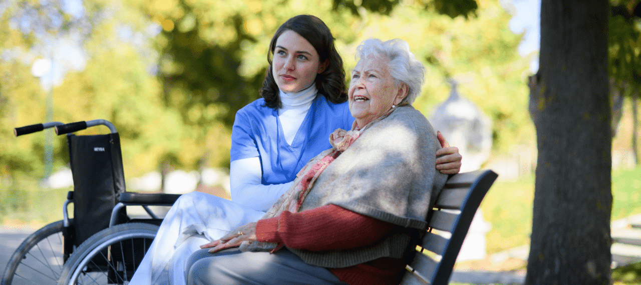 soignante avec une dame agee en fauteuil