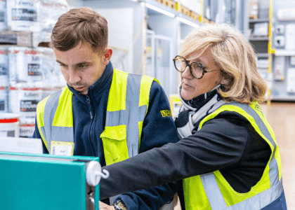 une employée aide un jeune alternant dans un magasin