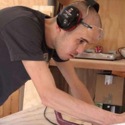 Jeune homme coupant du bois