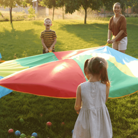 groupe d'enfants qui jouent dehors avec 2 parents