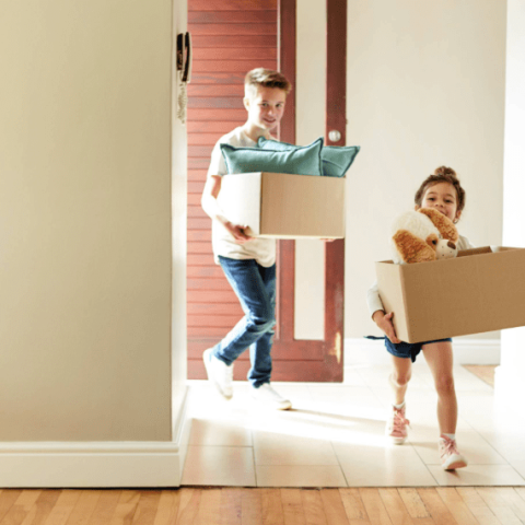 2 enfants entrent dans un nouvel appartement avec leurs cartons