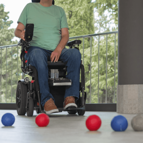 personne en fauteuil qui joue à la boccia