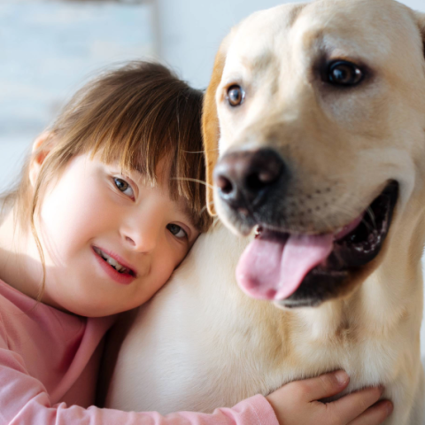 enfant trisomique qui fait un câlin à un handi'chien
