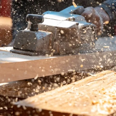 main sur une ponceuse à bois en plein travail