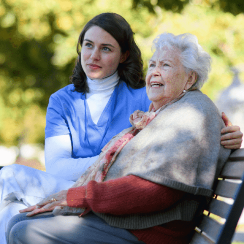 soignante avec une dame agee en fauteuil