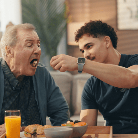 jeune homme qui donne à manger à son père