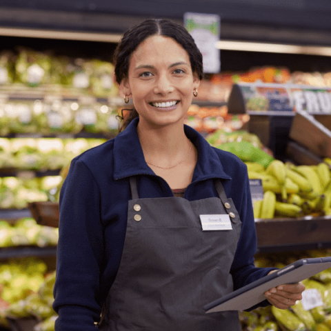 une employée de supermarché au rayon fruits
